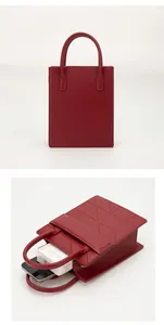Macro view of dark red PU leather handbag showing the geometric texture and interior capacity