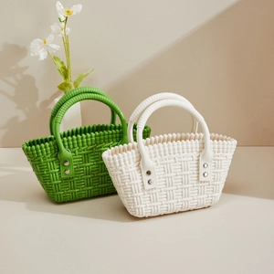 Detail der PVC-Flechtoptik-Tasche mit silbernen Nieten und rundem Tragegriff in Nahaufnahme