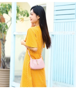 Pink PVC crescent hobo bag shown with metallic clasp and adjustable shoulder strap