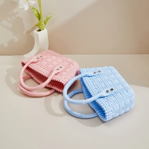 Detail von PVC-Korb-Taschen in Rosa und Blau mit Webstruktur und Metallnieten-Design