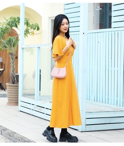 Close-up of pink mini flap crossbody bag paired with a yellow polka dot dress