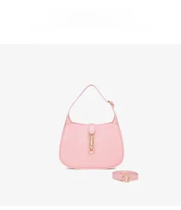 Detailed view of pink PVC crescent Hobo bag with golden piston lock and adjustable strap