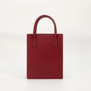 Minimalist red PU leather rectangular handbag with curved top handles in a sleek design