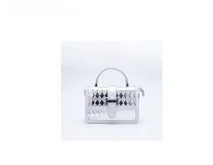Detail of silver quilted handbag with metallic top handle and secure metal clasp closure