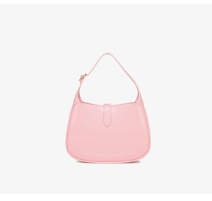 Detailed close-up of the light pink PVC crescent bag showing the gold buckle and glossy finish