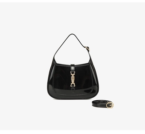 Detailed view of black patent PVC hobo bag featuring a gold piston lock and smooth texture