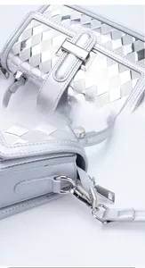 Detail showing silver metallic diamond quilted texture and polished metal buckle