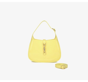 Detailed view of yellow PVC crescent bag with golden piston closure and shoulder strap
