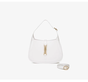 Detail of white PVC crescent bag with gold piston closure and adjustable shoulder strap