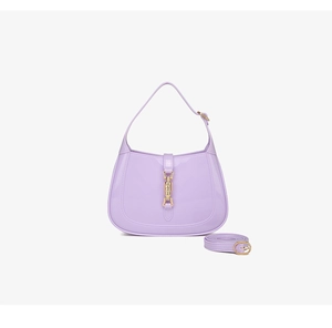 Detail view of the lavender PVC crescent bag with a metallic buckle and shoulder strap