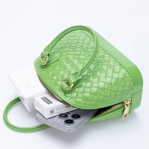 Bright green woven PVC shell bag with top handles showing spacious interior storage