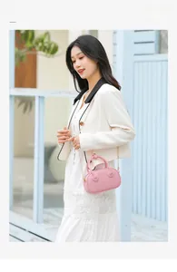 Detail view of pink PVC jelly bag with heart patches on a white suit model
