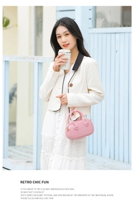 Pink jelly bag with 3D heart patterns and chain strap worn by a model in outdoor setting