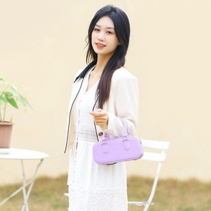 Elegante borsa a mano in PVC viola con finitura in pelle opaca indossata da una modella