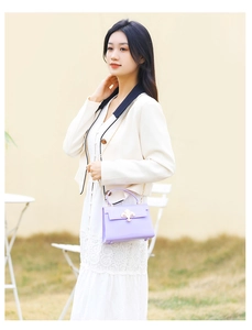 Vue détaillée du sac à main violet en PVC avec fermoir fleur de lys doré et bandoulière
