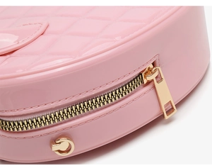 Close-up of pink PVC jelly bag with quilted diamond pattern and gold zipper detail