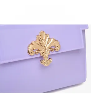 Détail du fermoir floral doré sur le sac à main en PVC lavande au fini brillant