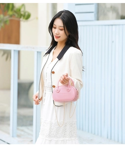 Chic pink jelly bag with heart pattern details on a white lace dress with chain strap