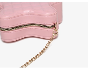 Vue macro d'un sac étoilé rose avec surpiqûres en losanges et détails de fermeture dorée