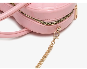 Detailed macro view of pink PVC jelly bag with gold zipper and diamond quilted texture