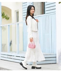 Outdoor view of a model carrying a stylish pink PVC jelly handbag with chain strap