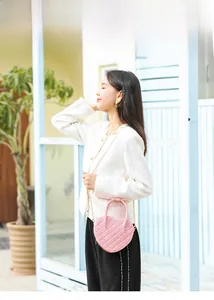 Detailed view of pink heart-shaped PVC jelly bag with gold chain strap in outdoor setting