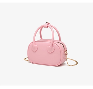 Detailed macro view of pink PVC jelly bag with heart accents and gold chain strap