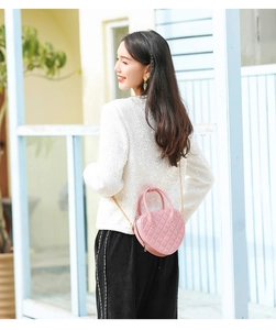 Close-up of pink heart-shaped jelly bag with quilted pattern and gold chain strap