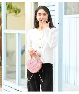 Detailed close-up of pink heart-shaped bag with quilted pattern and gold chain strap