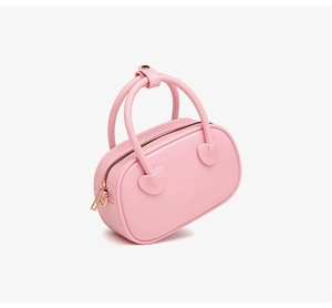 Detailed side view of pink PVC jelly bag with heart accents and gold zipper closure