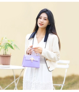 Gros plan d'un mini sac à main lilas avec boucle dorée vintage porté par un mannequin