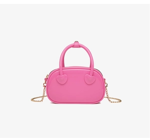 Detail of trendy Barbie pink PVC jelly bag showing heart-shaped handle attachments and gold chain