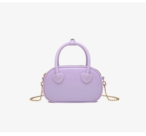 Detail of lavender PVC jelly bag featuring heart charms and gold chain strap