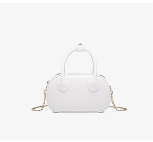 Close-up of white PVC jelly bag featuring gold chain strap and heart-shaped metal detail
