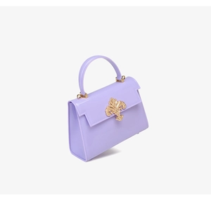 Détail du mini sac à main lilas en PVC brillant avec fermoir floral doré élégant