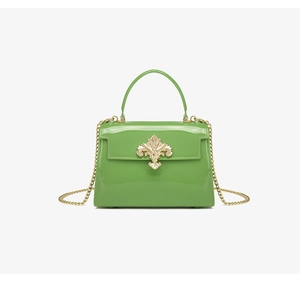Vue détaillée du sac en PVC vert avec boucle dorée en forme de fleur de lys
