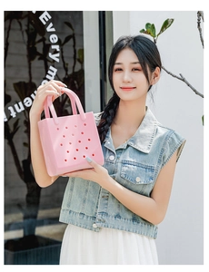Pink EVA perforated beach tote bag with a circular hollow design held by a female model