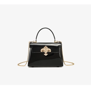 Vue détaillée du sac en cuir verni noir avec boucle florale dorée de luxe