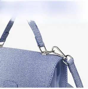 Vue détaillée du sac bandoulière texturé bleu et blanc avec finitions en métal argenté