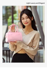 Pink PVC jelly Boston handbag shown in a lifestyle setting at an outdoor cafe