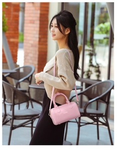 Detailed view of glossy pink PVC jelly handbag with golden hardware for women