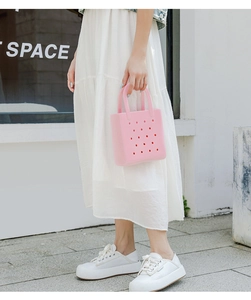 Outdoor shot of a pink perforated EVA beach tote bag featuring a minimalist hollow design