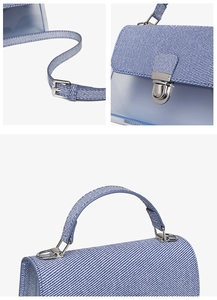 Detail of silver metal clasp and blue striped handle on a transparent jelly handbag