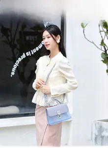 Detailed view of light blue jelly crossbody bag with metallic clasp and woven texture