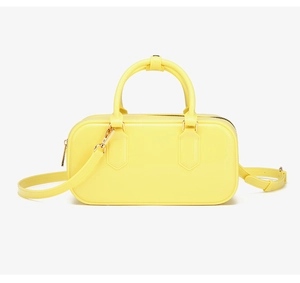 Detalle de bolso jelly amarillo en PVC con herrajes dorados y doble cremallera