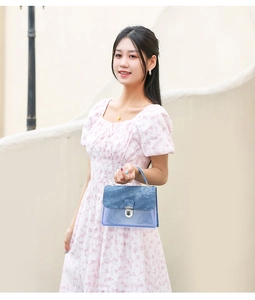 Detalle del bolso de mezclilla azul y PVC transparente con cierre metálico plateado seguro