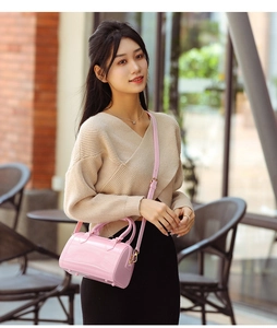 Detailed view of pink jelly PVC Boston bag with gold hardware and reinforced handles