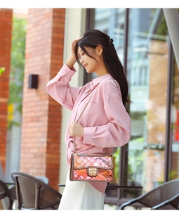 Detailed view of pink laser PVC crossbody bag with diamond quilting and gold chain