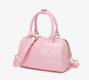 Detailed side view of pink PVC jelly Boston bag with gold hardware and shoulder strap
