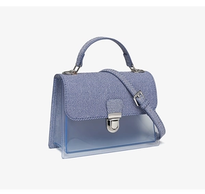 Detail of blue striped jelly crossbody bag with transparent body and silver metal lock